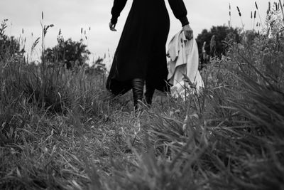 Low section of people walking on field