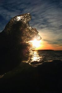 Scenic view of sea against dramatic sky during sunset