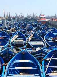 Sailboats moored at harbor against clear blue sky