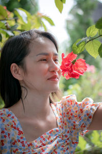 Portrait of beautiful woman with red flower