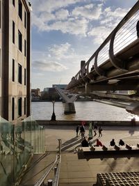 People on boat in river against buildings