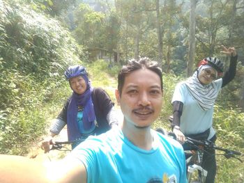 Portrait of happy friends standing in forest