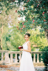 Portrait of smiling young woman holding bouquet