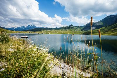 Scenic view of lake by mountains against sky 