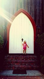 Girl standing against built structure