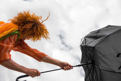 Woman holding umbrella while standing outdoors