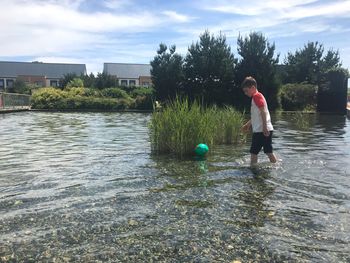 Boy playing with ball in lake