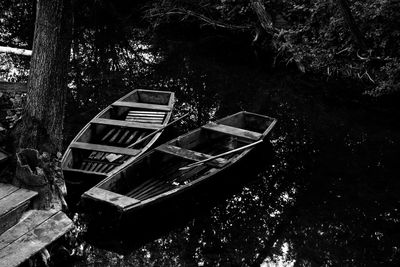 Abandoned boat moored on river in forest