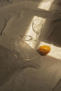 High angle view of wineglasses with orange fruit on table