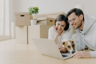 Smiling woman using mobile phone in laptop