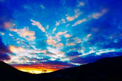 Low angle view of silhouette mountain against dramatic sky