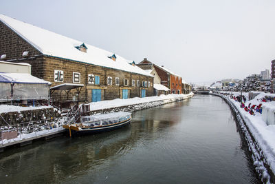 River amidst buildings in city against clear sky