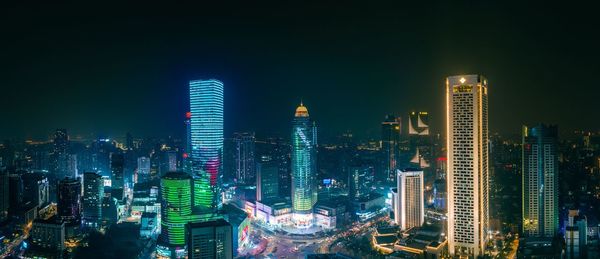 Illuminated buildings in city against sky at night