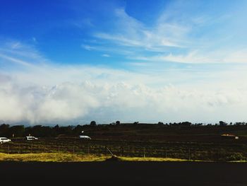 Scenic view of field against cloudy sky