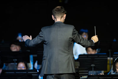 Rear view of man standing at music concert