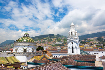 Historic church in city against cloudy sky
