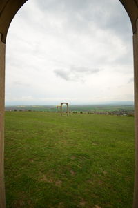 Scenic view of field against cloudy sky