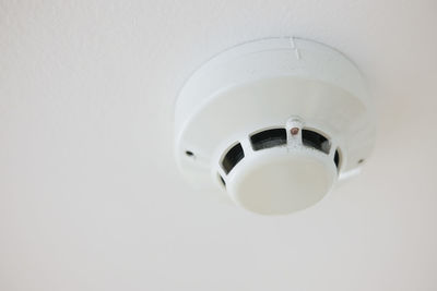 Low angle view of electric lamp against white background