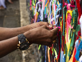 Midsection of man holding multi colored store