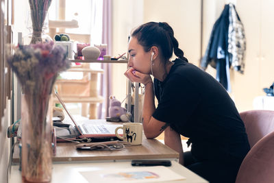 Side view of woman using mobile phone