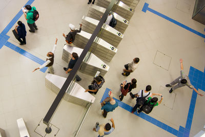 High angle view of people walking on tiled floor