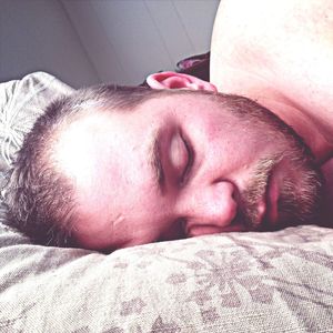 Close-up of sleeping cat lying on bed