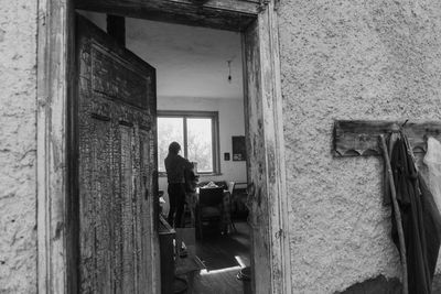 Side view of man standing against old building