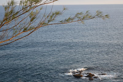 High angle view of rocks by sea against sky