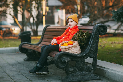 Portrait of man sitting on bench in park