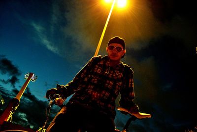 Low angle view of man wearing sunglasses against sky