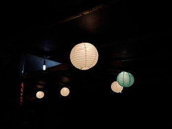 Low angle view of illuminated pendant lights hanging from ceiling