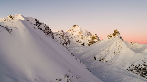 Scenic view of snowcapped mountains against clear sky