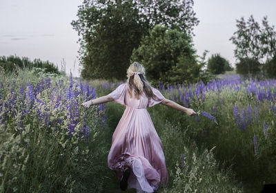 Rear view of woman standing on field