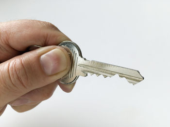 Close-up of man holding hand over white background