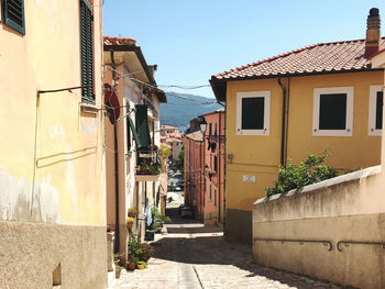 Footpath amidst buildings against sky