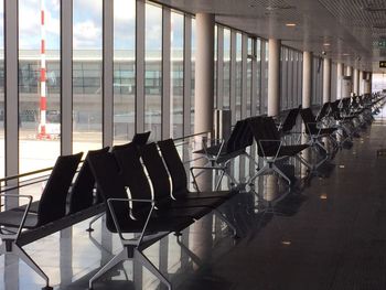 Empty chairs at airport departure area