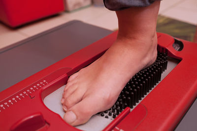 Low section of person standing on medical equipment