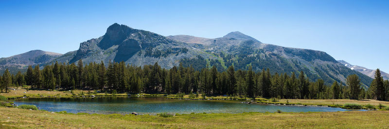 Scenic view of lake and mountains against clear blue sky