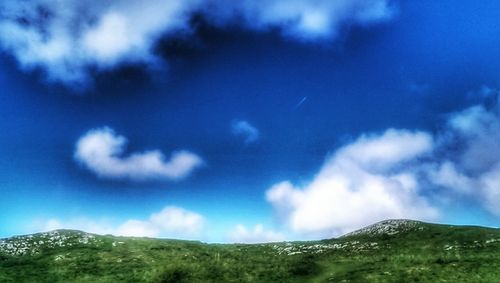 Scenic view of mountains against cloudy sky