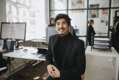 Portrait of smiling businessman wearing blazer sitting at office