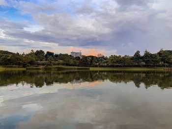Scenic view of lake by trees against sky