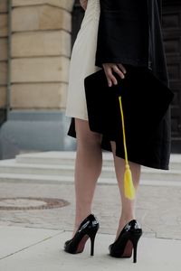 Low section of woman standing on footpath