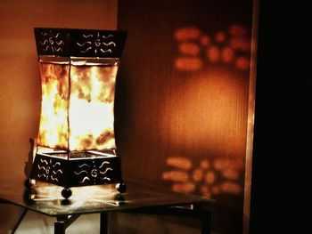 Close-up of illuminated candles on table at home