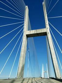 Low angle view of suspension bridge against clear blue sky