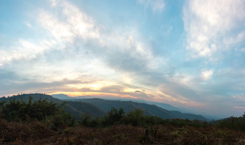 Scenic view of mountains against cloudy sky