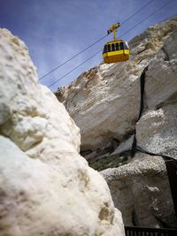 Low angle view of overhead cable car against sky