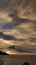 Scenic view of sea against dramatic sky during sunset