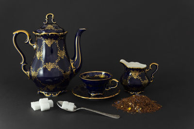 Close-up of tea cup on table against black background