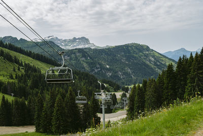 Overhead cable car on mountains against sky