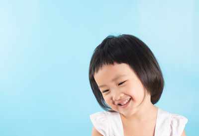 Portrait of a smiling girl against blue background